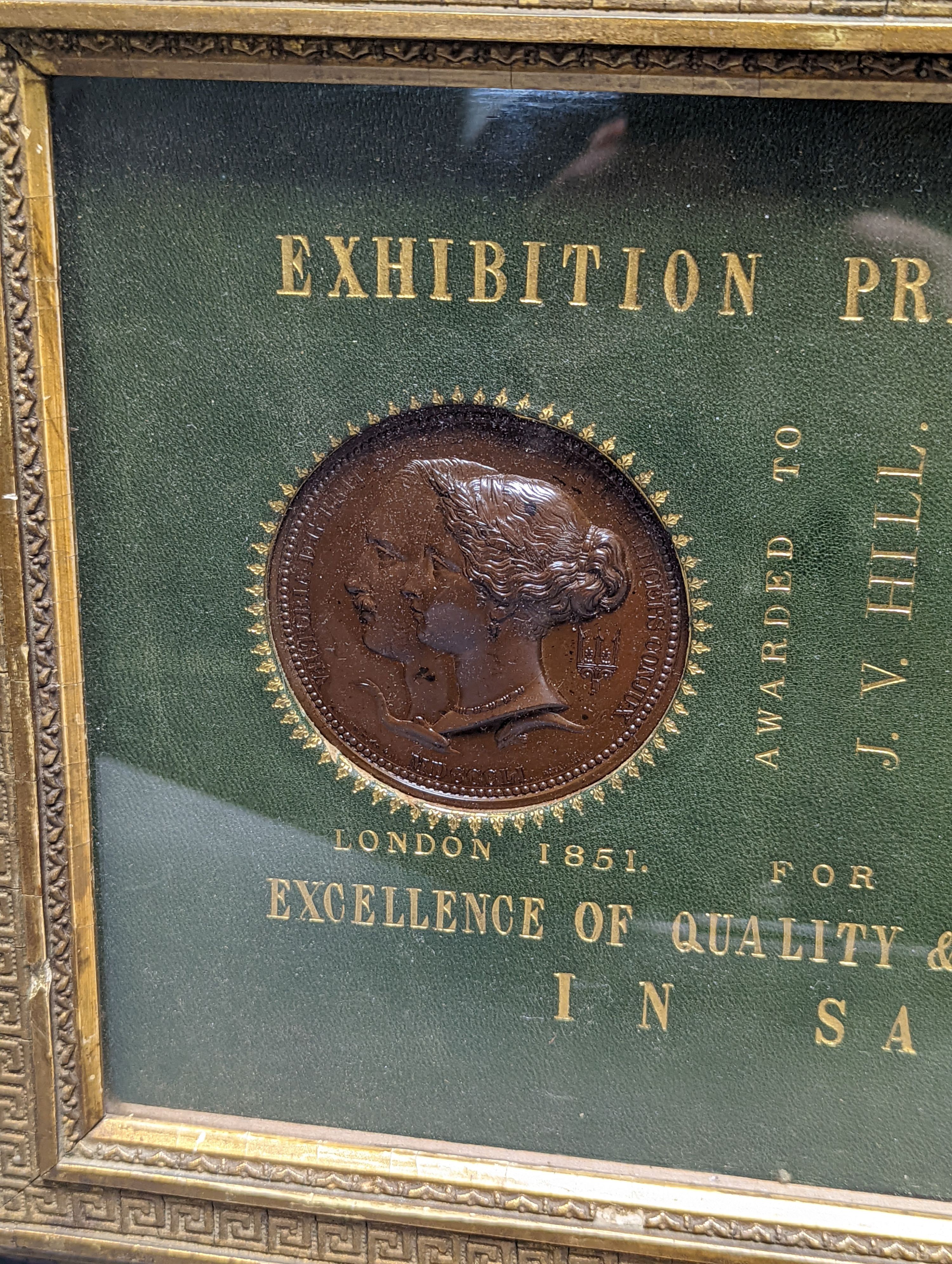 Two Exhibition Prize Medals, to JV Hill, saw manufacturers, London 1851 and Paris 1855, frame 34cm. wide, and a collection of Victorian coin tokens, in Pinches & Co. case, 1857
